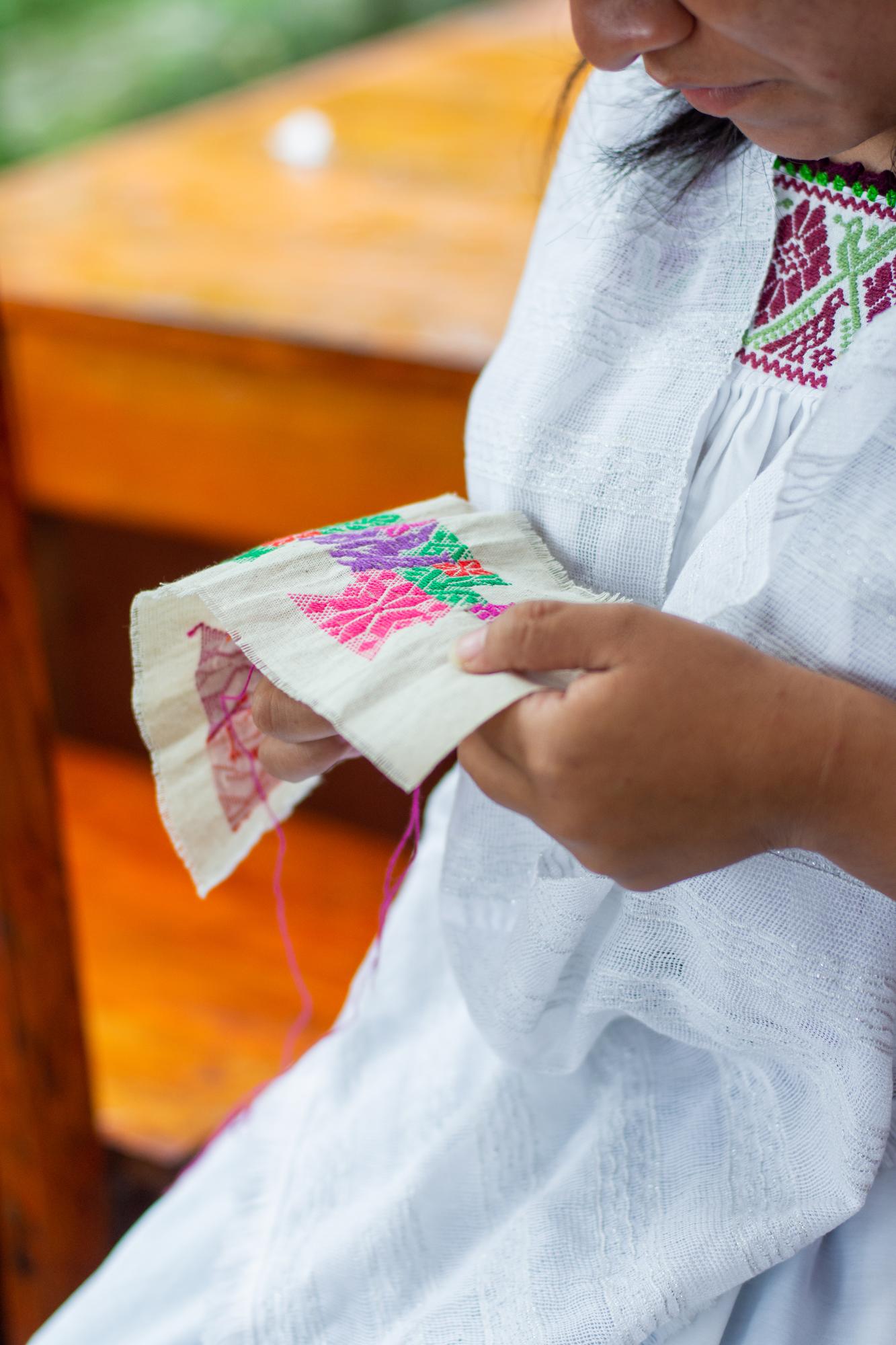 Hands holding embroidered fabric